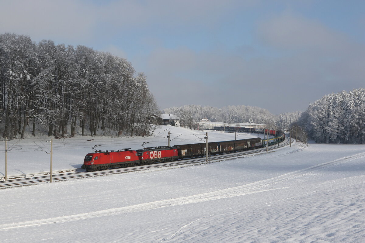 1116 027 und 1293 049 waren mit einem gemischten G�terzug am 13. Januar 2024 bei Axdorf im Chiemgau in Richtung Rosenheim unterwegs.