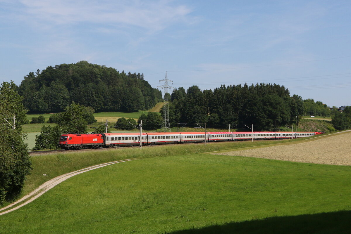 1116 148 war am 13. Juni 2025 mit einem  EC  bei Vachendorf im Chiemgau in Richtung M�nchen unterwegs.