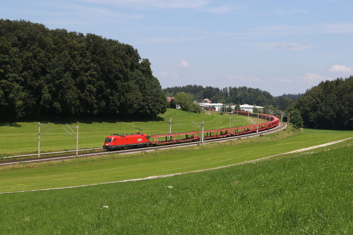 1116 187 mit einem Autoleerzug aus Freilassing kommend am 9. Juli 2024 bei Axdorf.